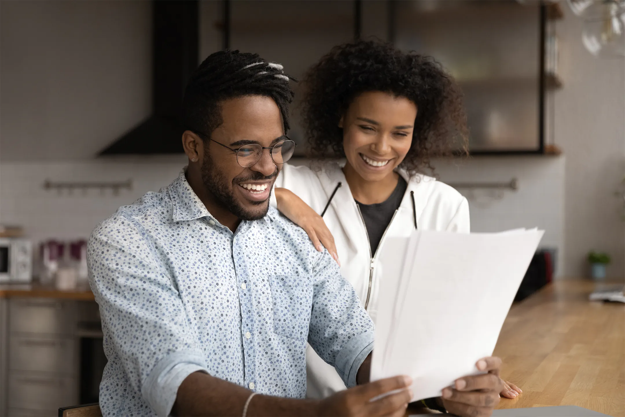 Smiling couple reviewing financial documents at home