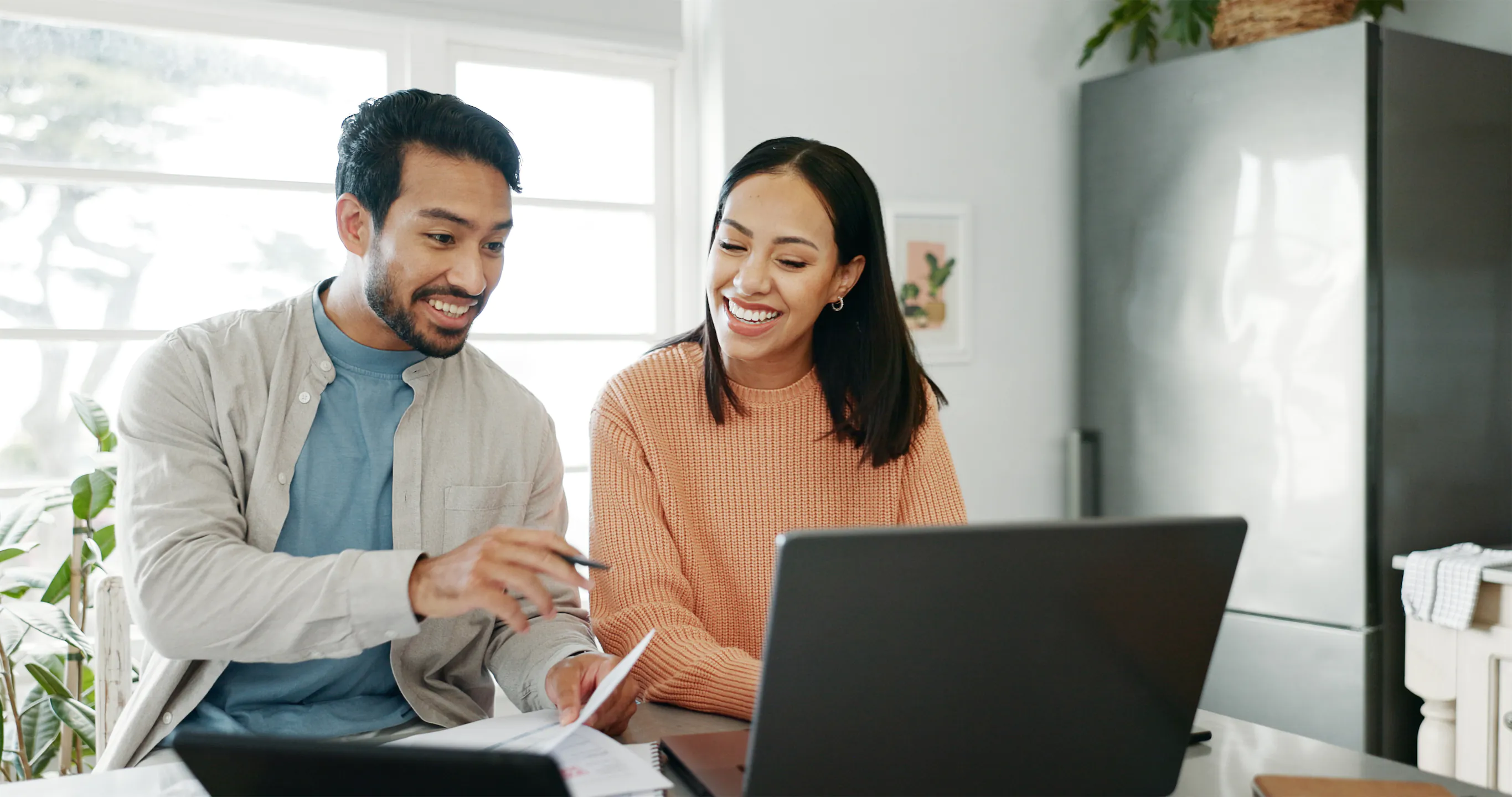 Smiling couple reviewing tax documents together at home